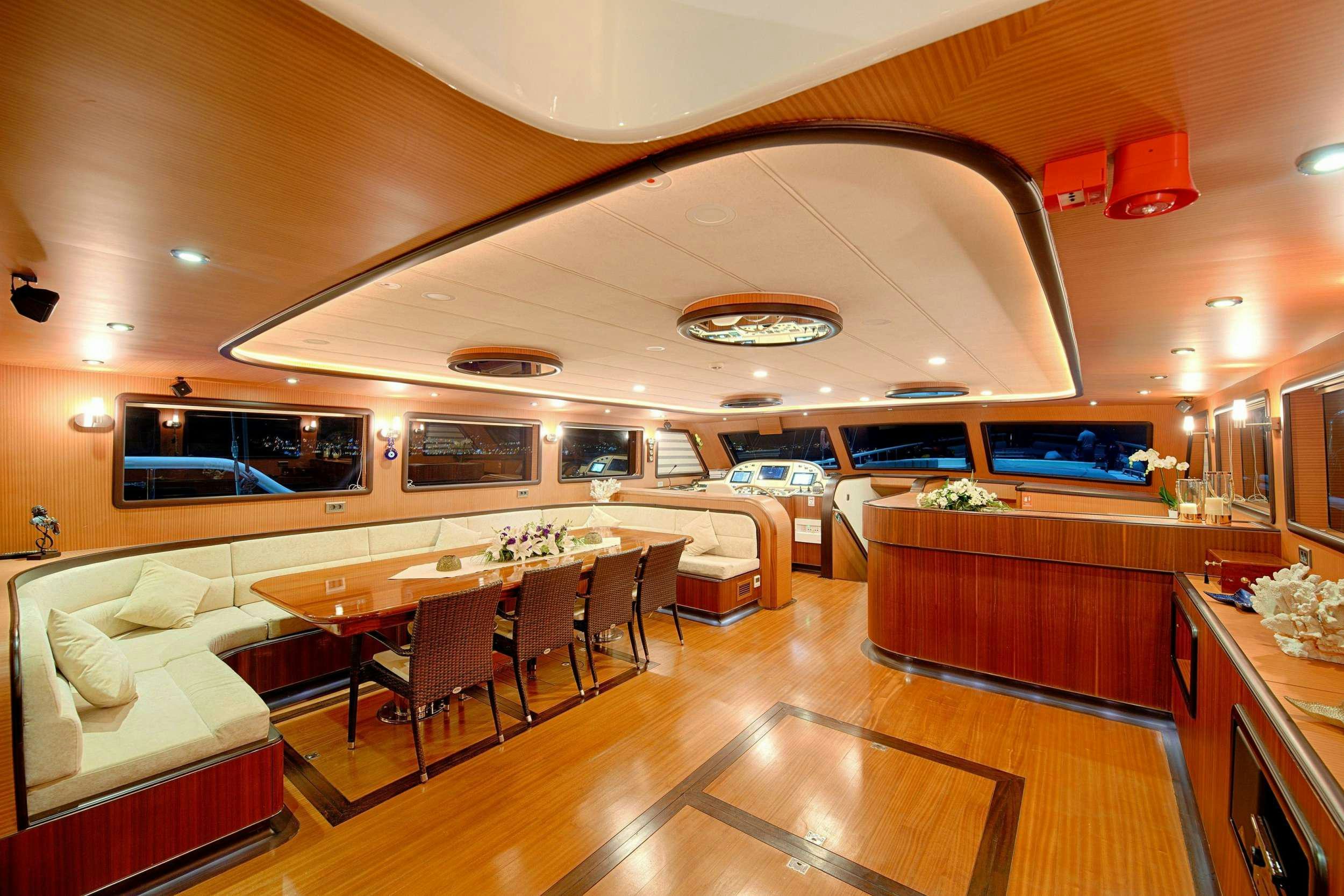 a large room with a table and chairs aboard QUEEN OF SALMAKIS Yacht for Charter