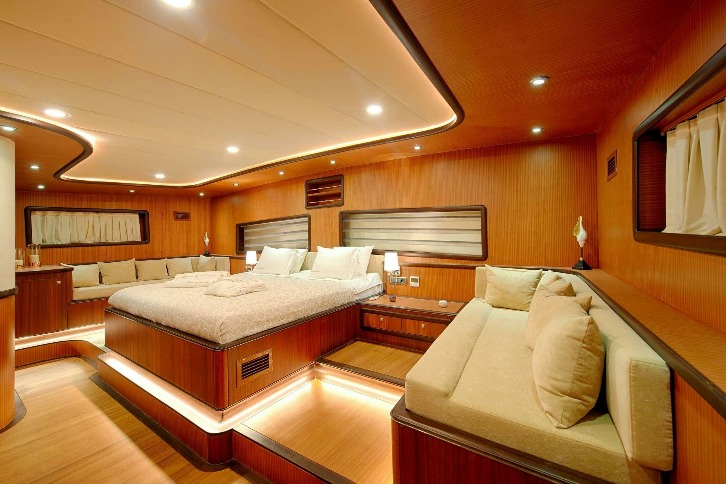 a hotel room with a bed and a couch aboard QUEEN OF SALMAKIS Yacht for Charter