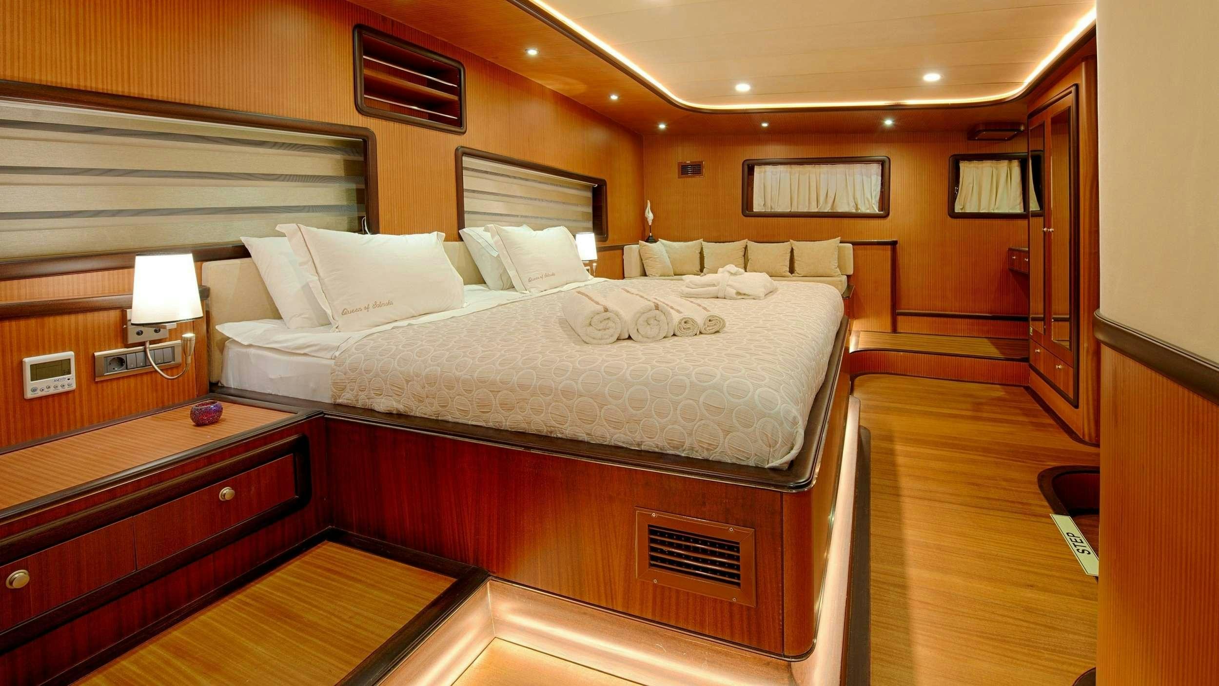 a room with a bed and a desk aboard QUEEN OF SALMAKIS Yacht for Charter