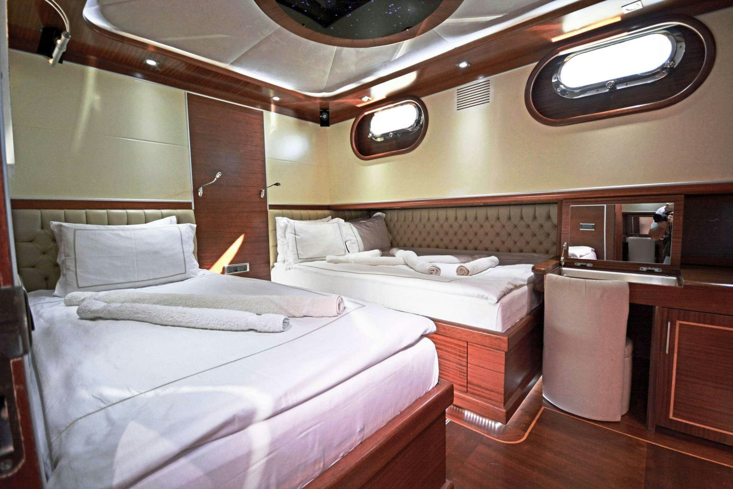 a room with beds and a chair aboard DOLCE MARE Yacht for Charter