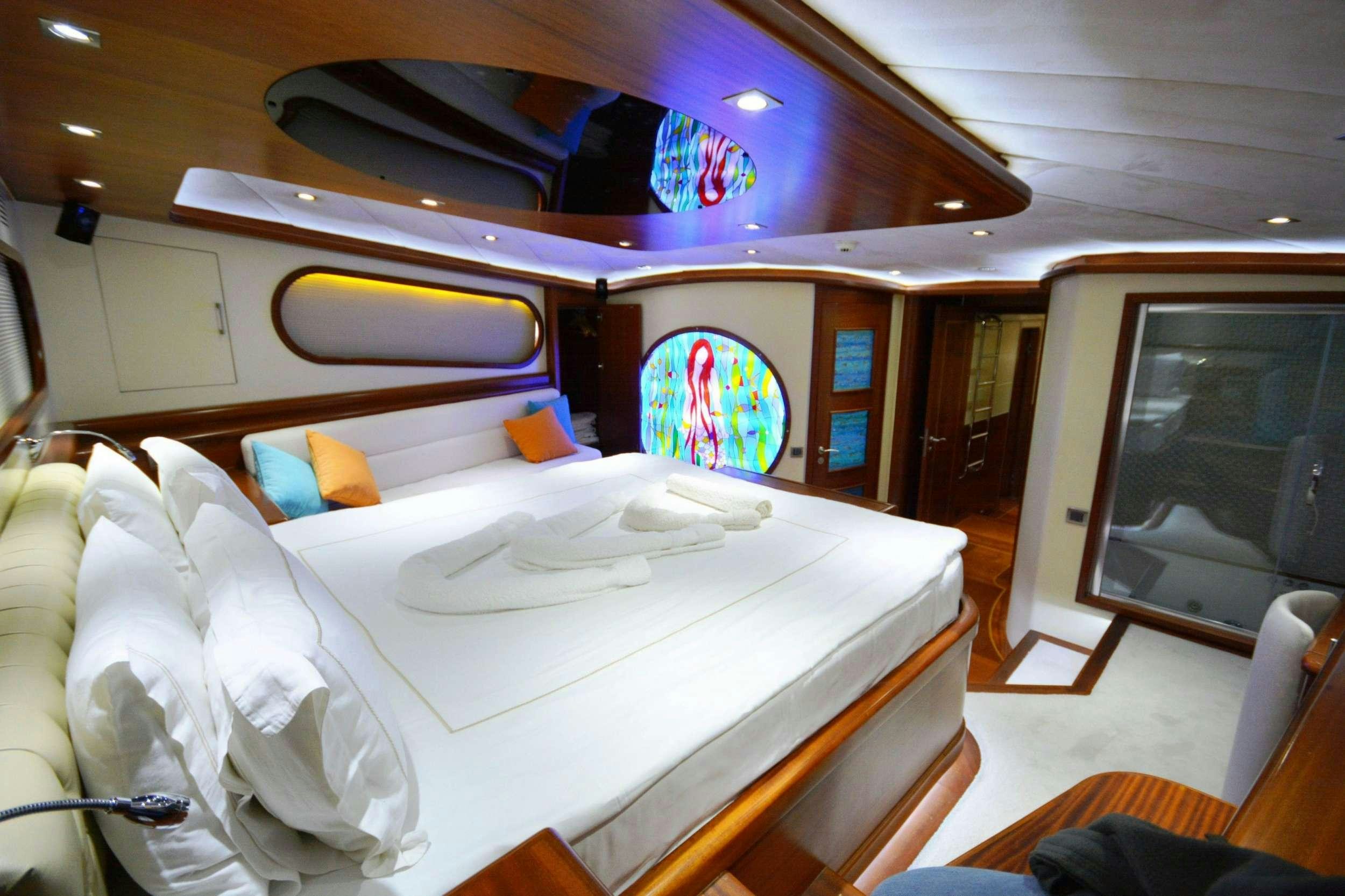 a room with a bed and a television aboard DOLCE MARE Yacht for Charter