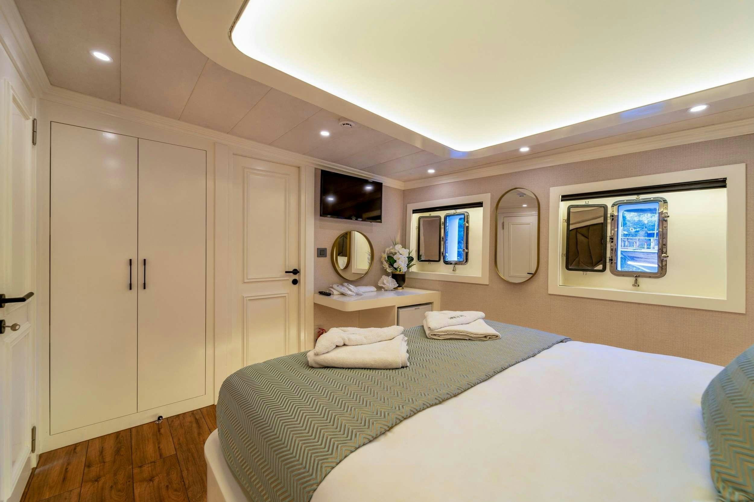 a bedroom with a bed and a desk aboard QUEEN OF MAKRI Yacht for Charter