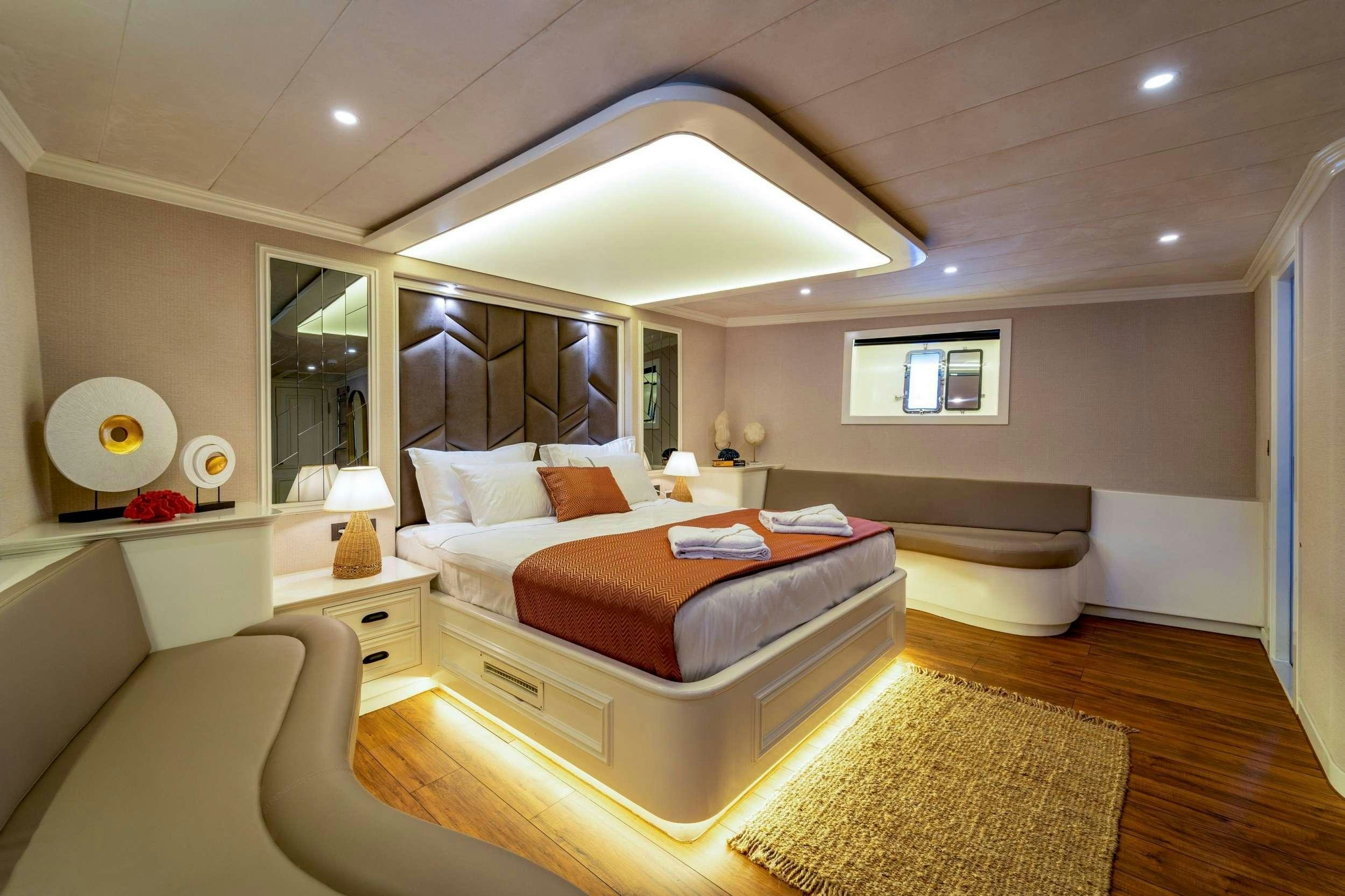 a room with a bed and a window aboard QUEEN OF MAKRI Yacht for Charter