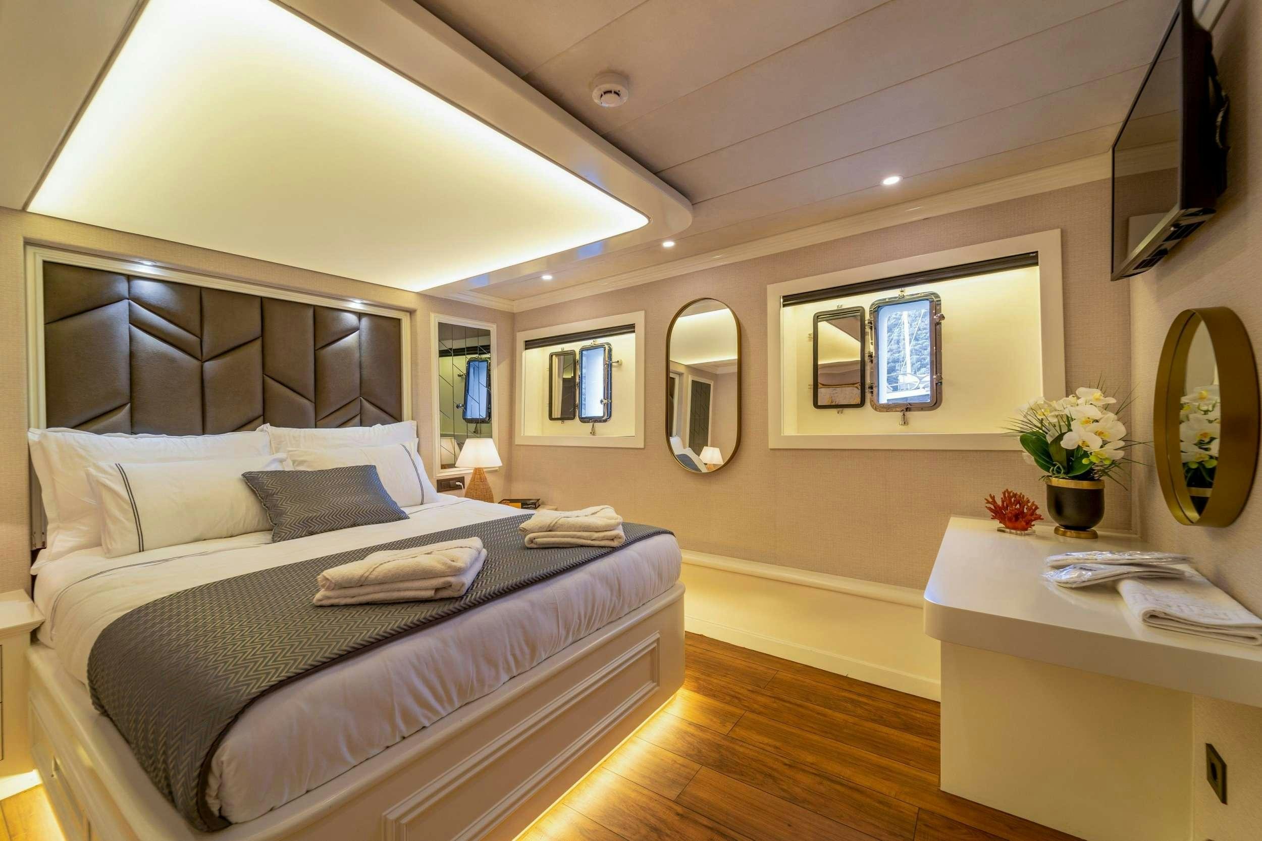 a bedroom with a bed and a desk aboard QUEEN OF MAKRI Yacht for Charter