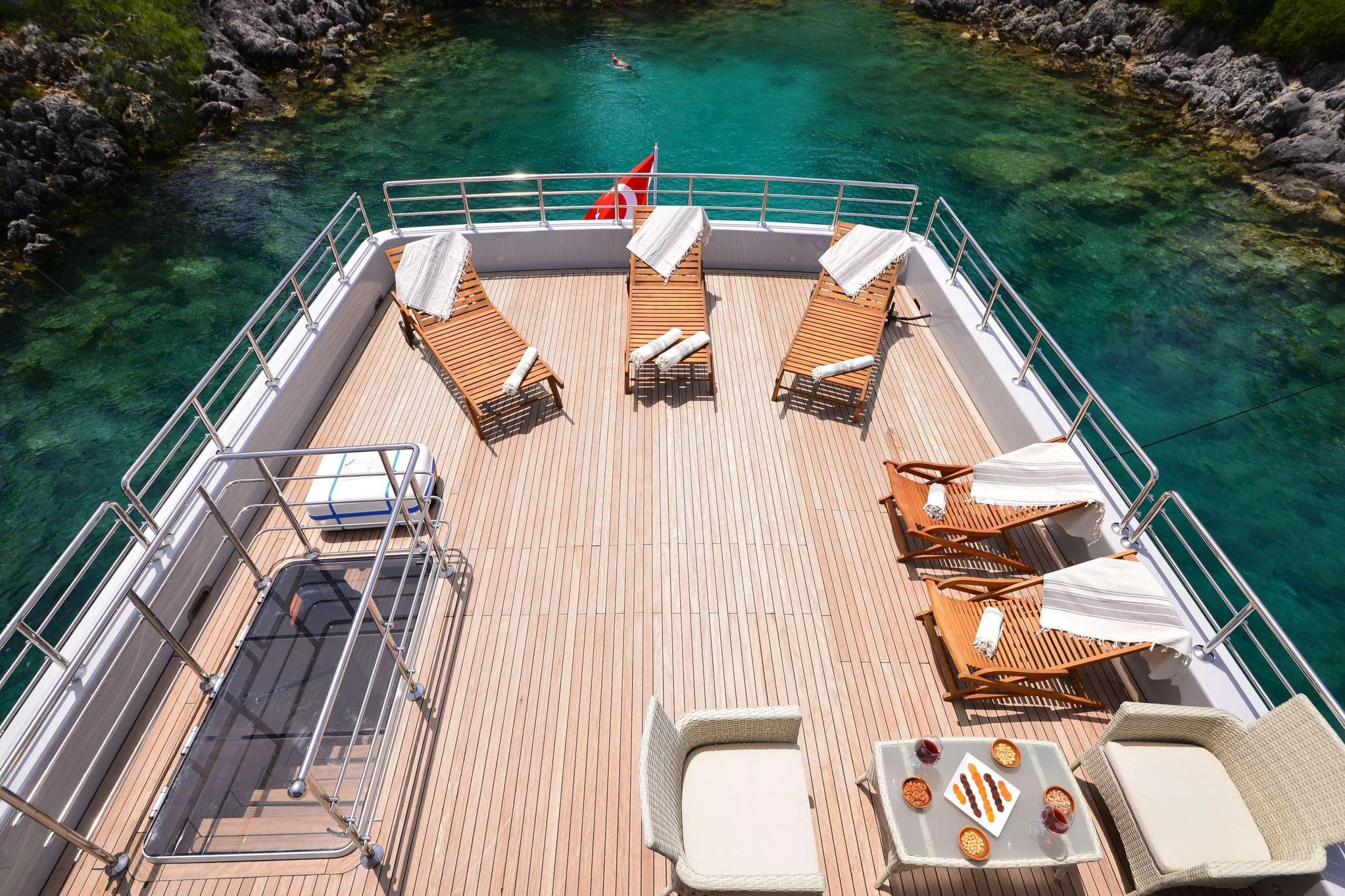 a deck with a dock and chairs aboard IMMERSIVE Yacht for Charter