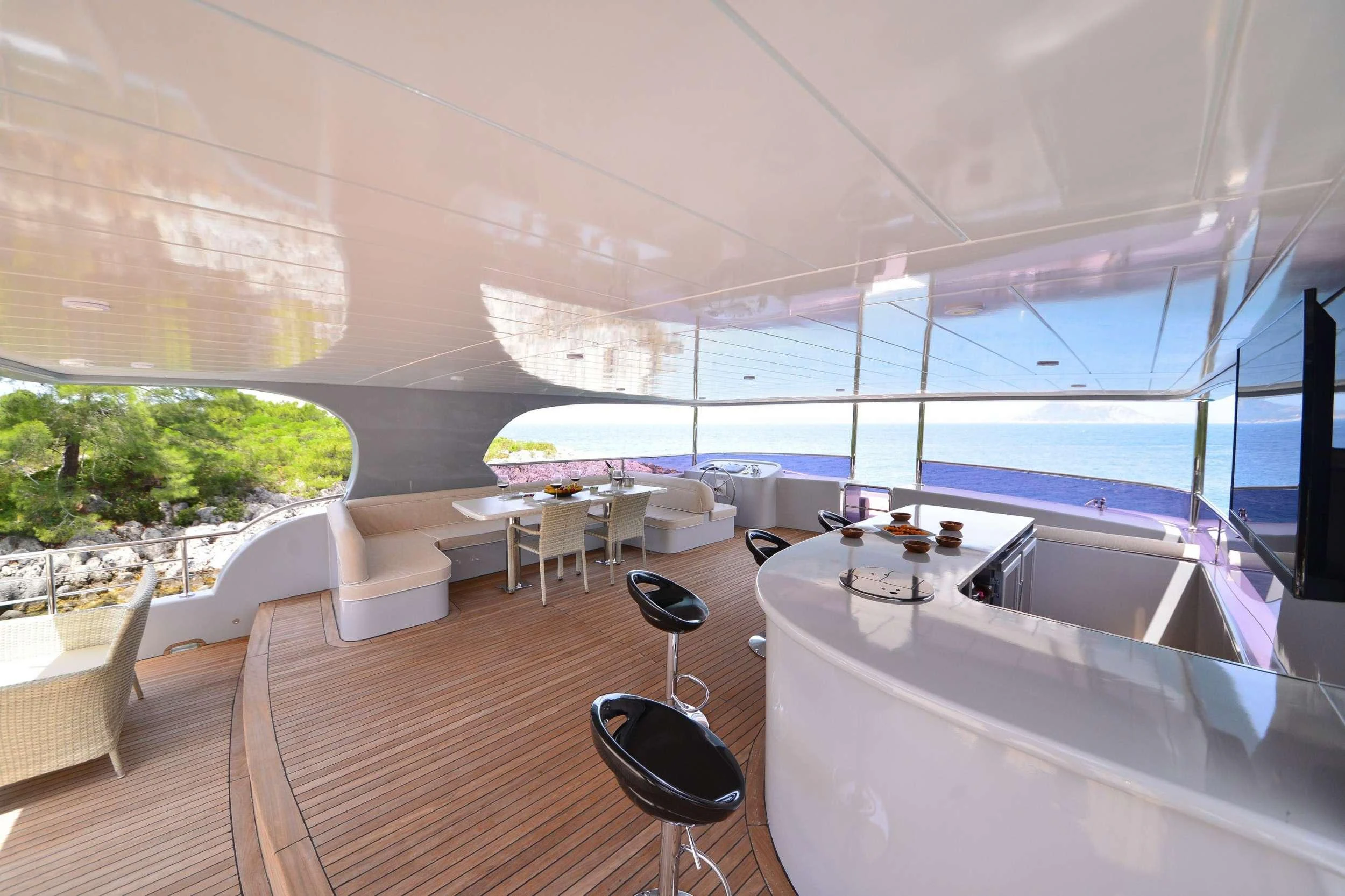 a room with a large window and a table with chairs and a large pool aboard IMMERSIVE Yacht for Charter