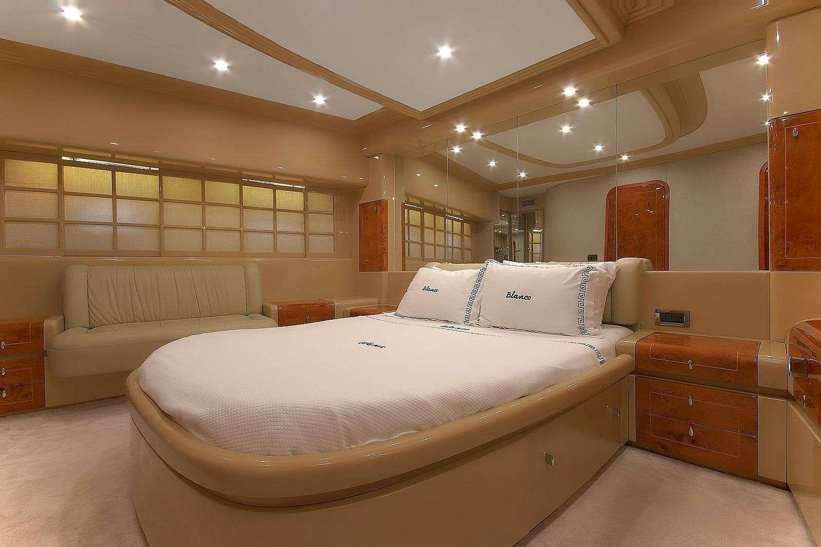 a room with a bed and a dresser aboard BLANCO Yacht for Charter