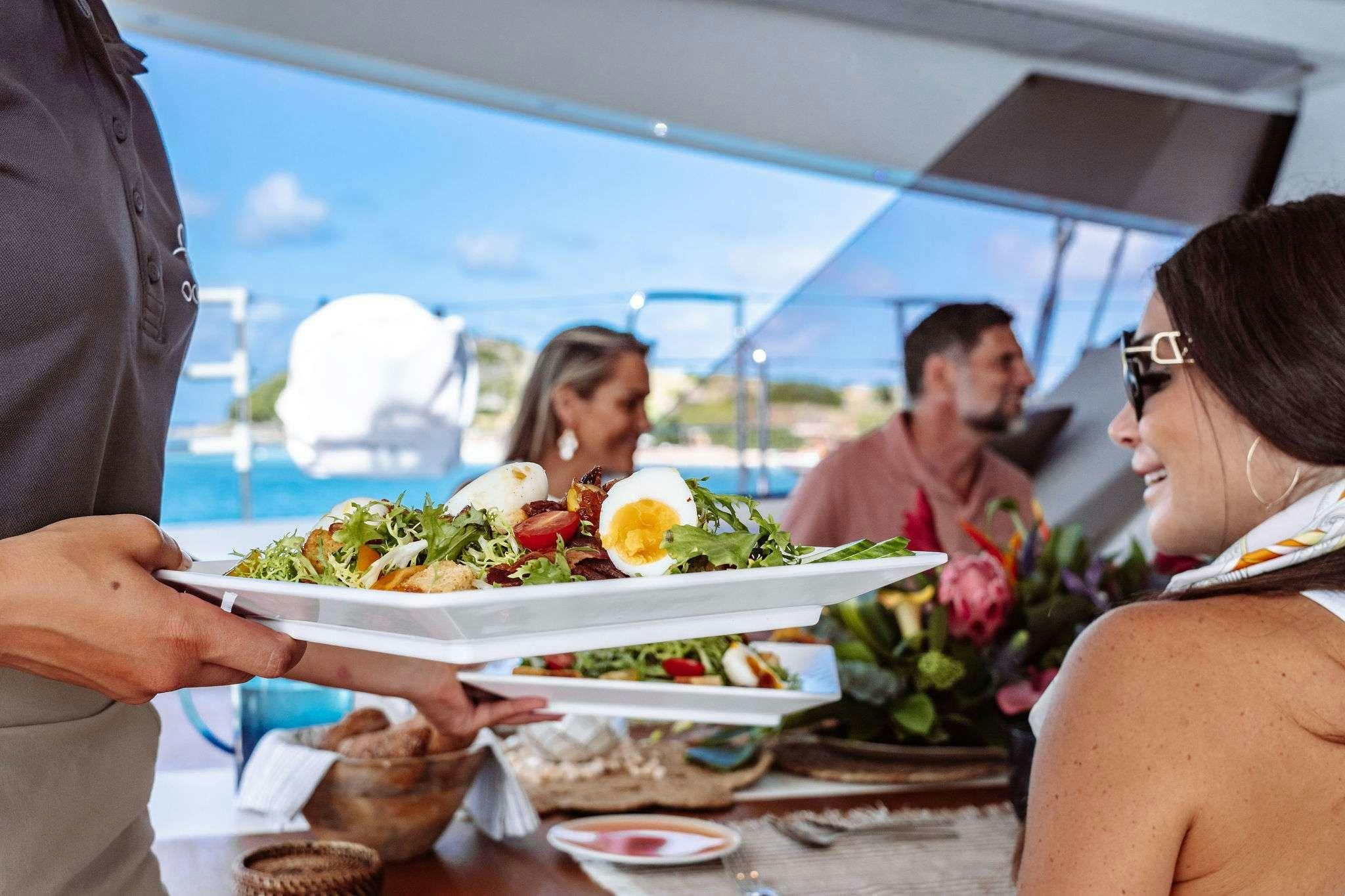 a group of people eating food aboard OCEANUS Yacht for Charter