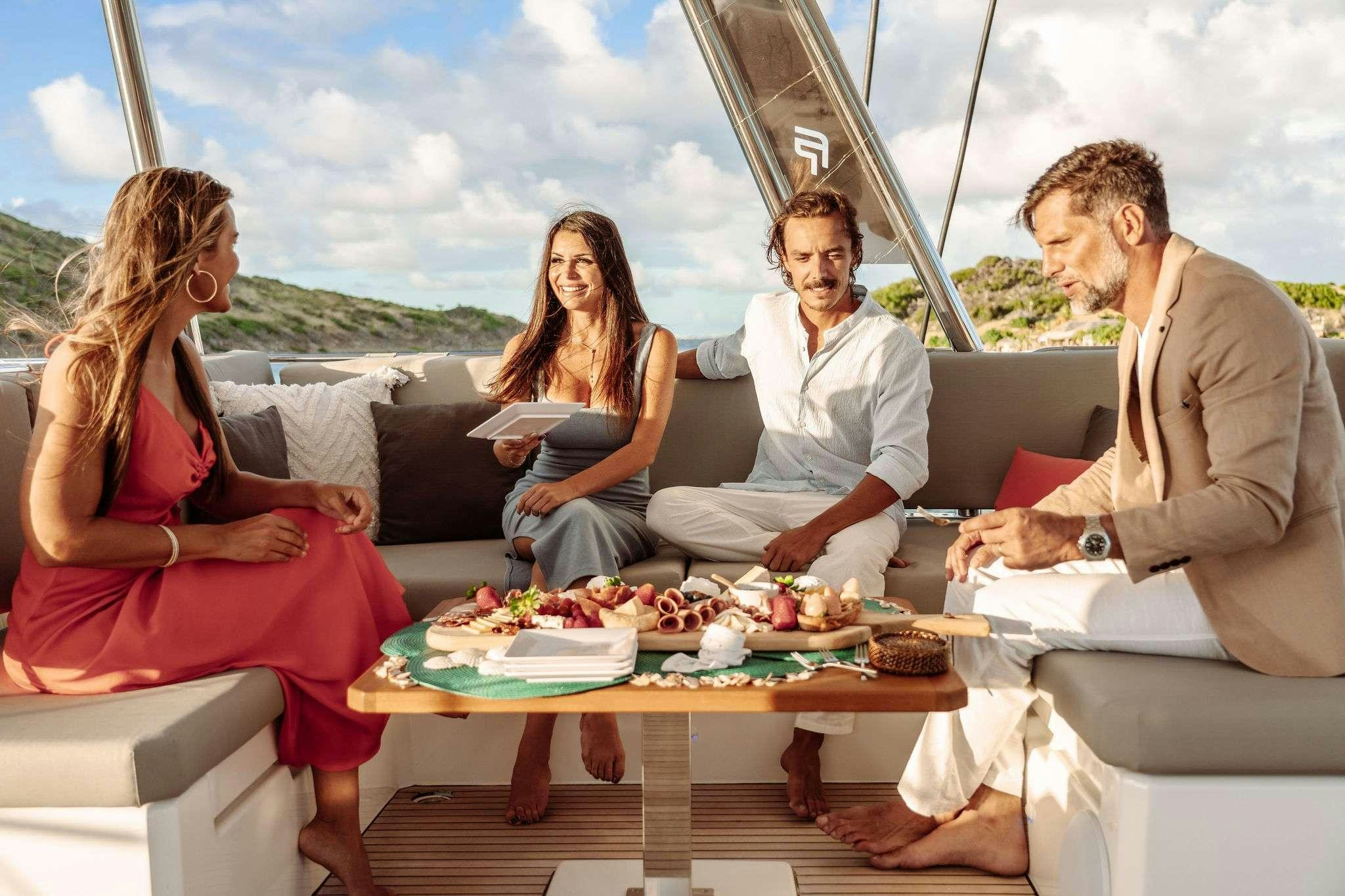 a group of people sitting around a table outside aboard OCEANUS Yacht for Charter