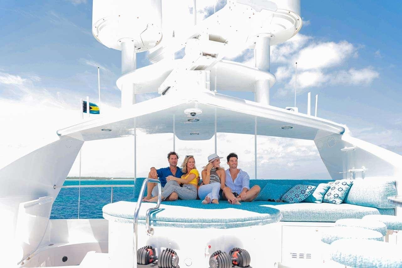 a group of people sitting on a large white object aboard CUPCAKE Yacht for Charter