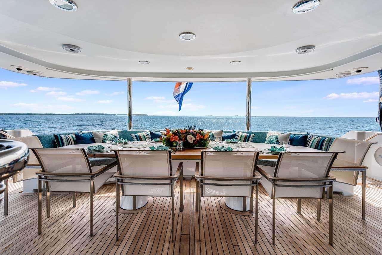 a table and chairs on a deck overlooking a body of water aboard CUPCAKE Yacht for Charter