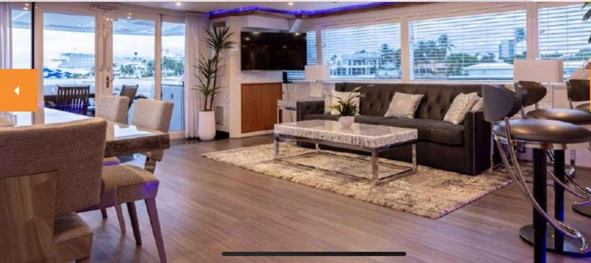 a living room with a couch and a coffee table aboard 105' POOLE Yacht for Charter