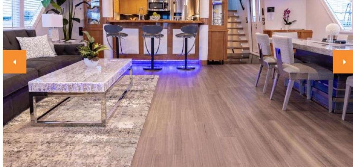 a living room with a couch and a table aboard 105' POOLE Yacht for Charter