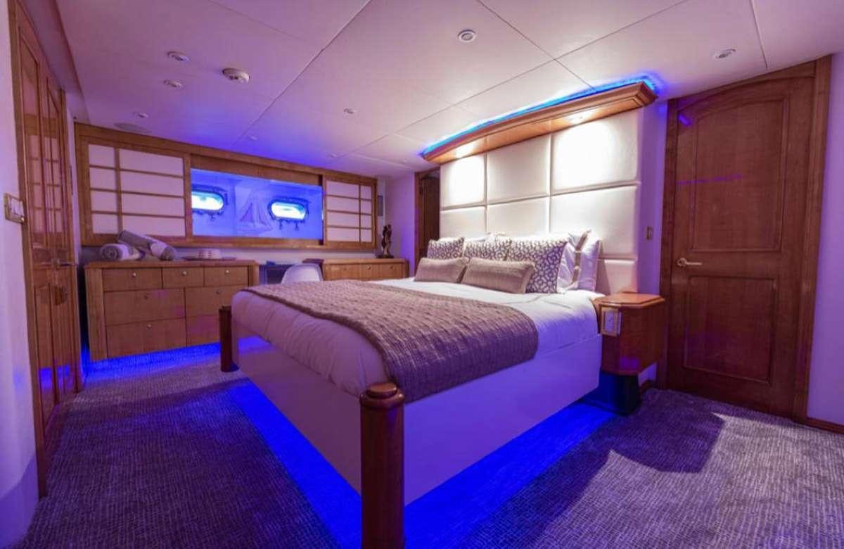 a bedroom with a bed and a desk aboard 105' POOLE Yacht for Charter