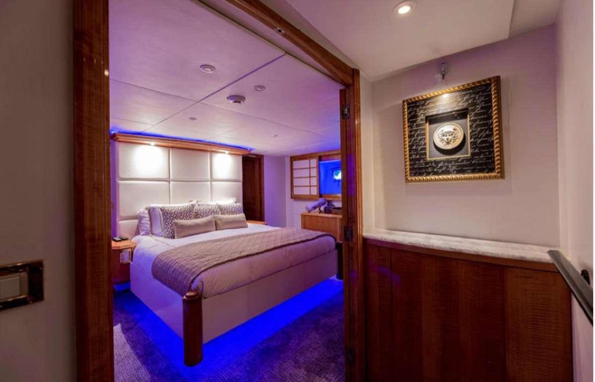 a bedroom with a bed and a mirror aboard 105' POOLE Yacht for Charter