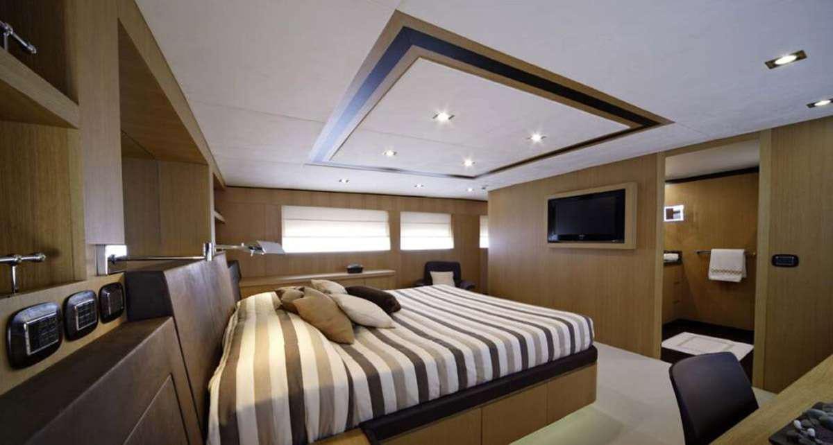 a room with a bed and a television aboard BLUE HEAVEN 2 Yacht for Charter