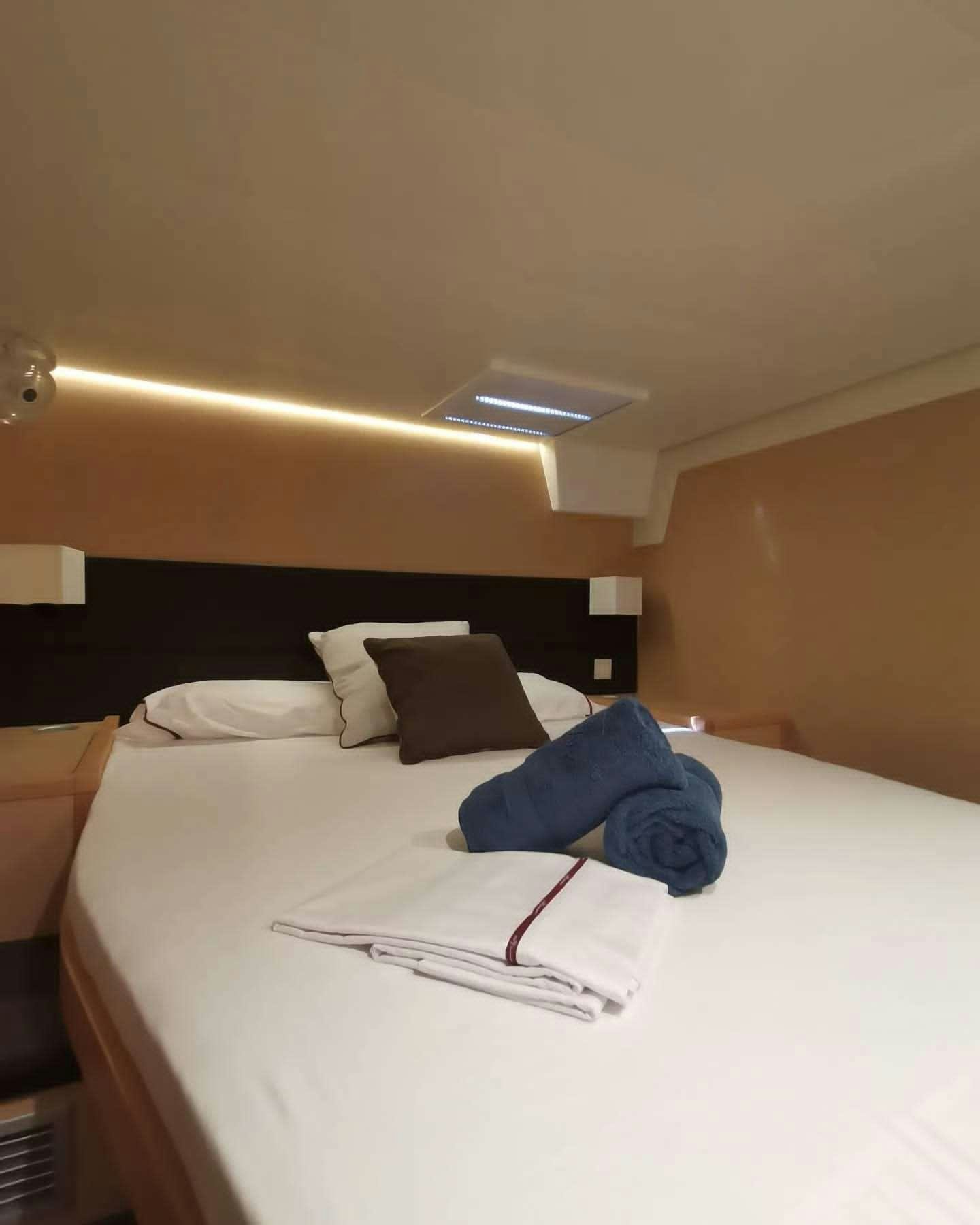 a bed with a blue pillow aboard ISLAS CHAFARINAS  Yacht for Charter