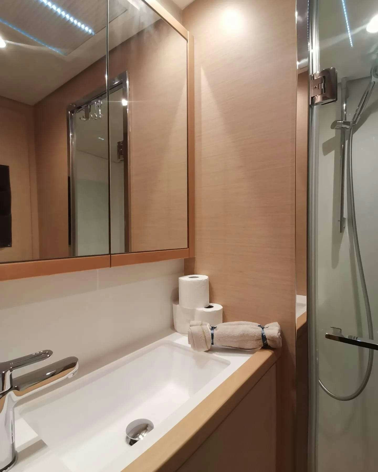 a bathroom with a sink and a shower aboard ISLAS CHAFARINAS  Yacht for Charter