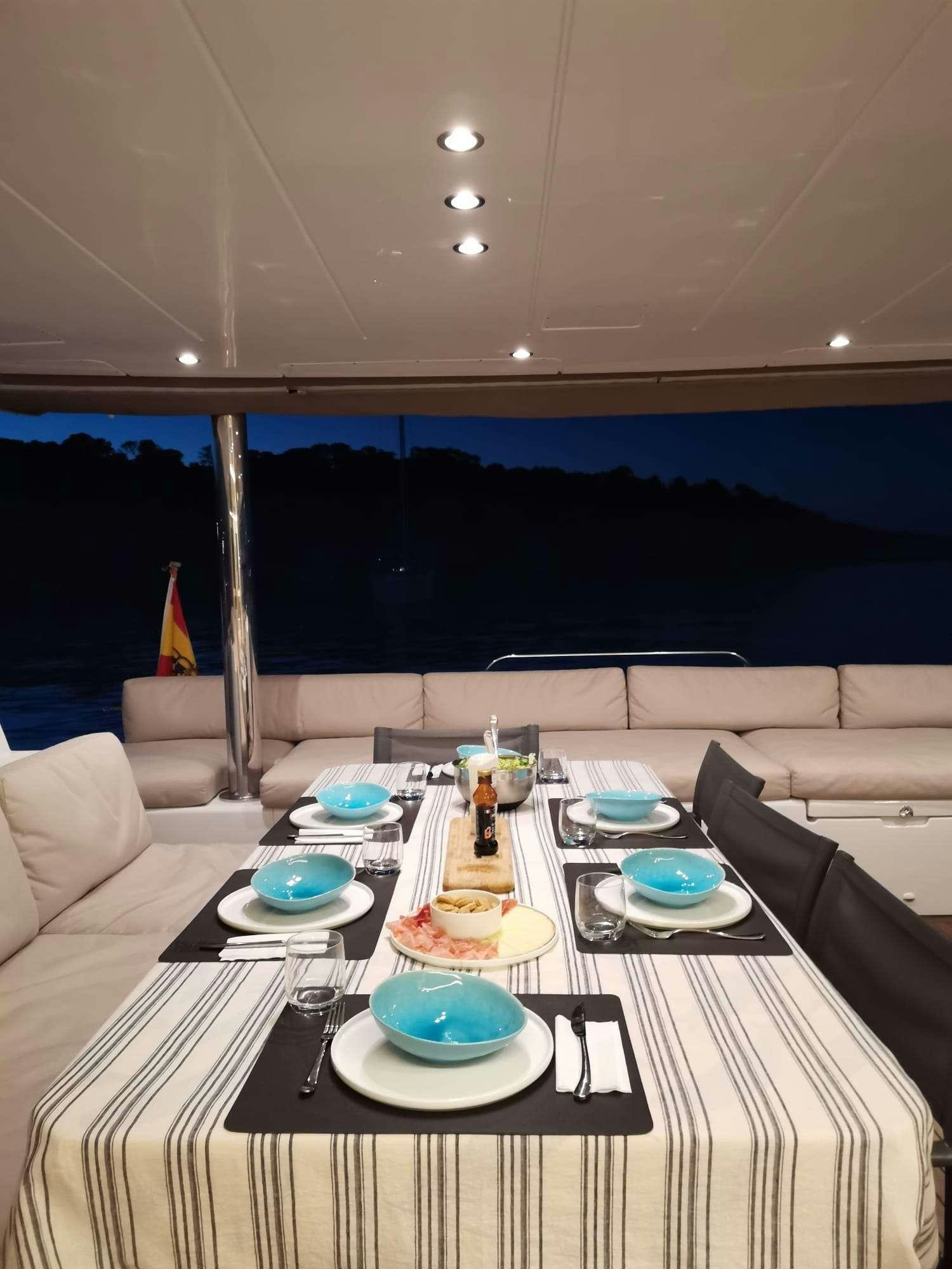 a table with plates and cups on it aboard ISLAS CHAFARINAS  Yacht for Charter
