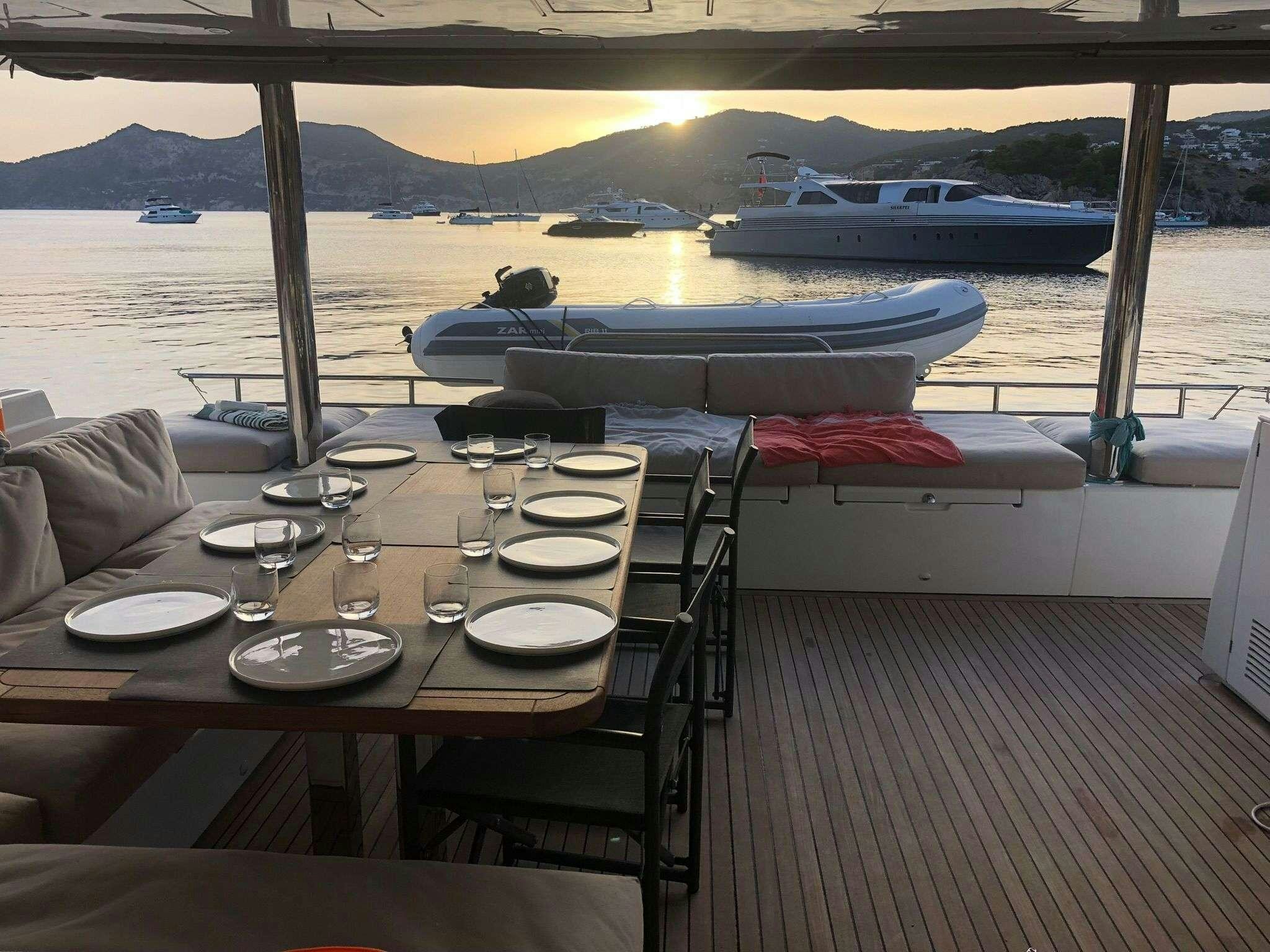 a table with plates and glasses on it aboard ISLAS CHAFARINAS  Yacht for Charter
