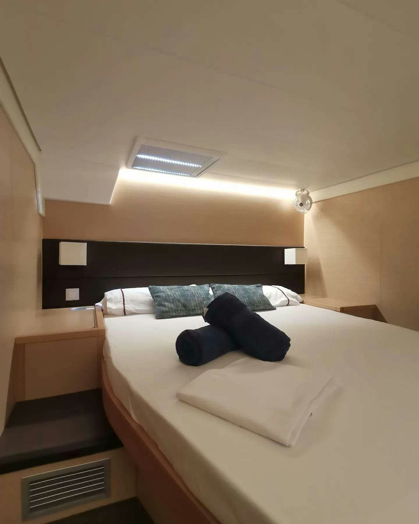 a bed with a white bed spread aboard ISLAS CHAFARINAS  Yacht for Charter