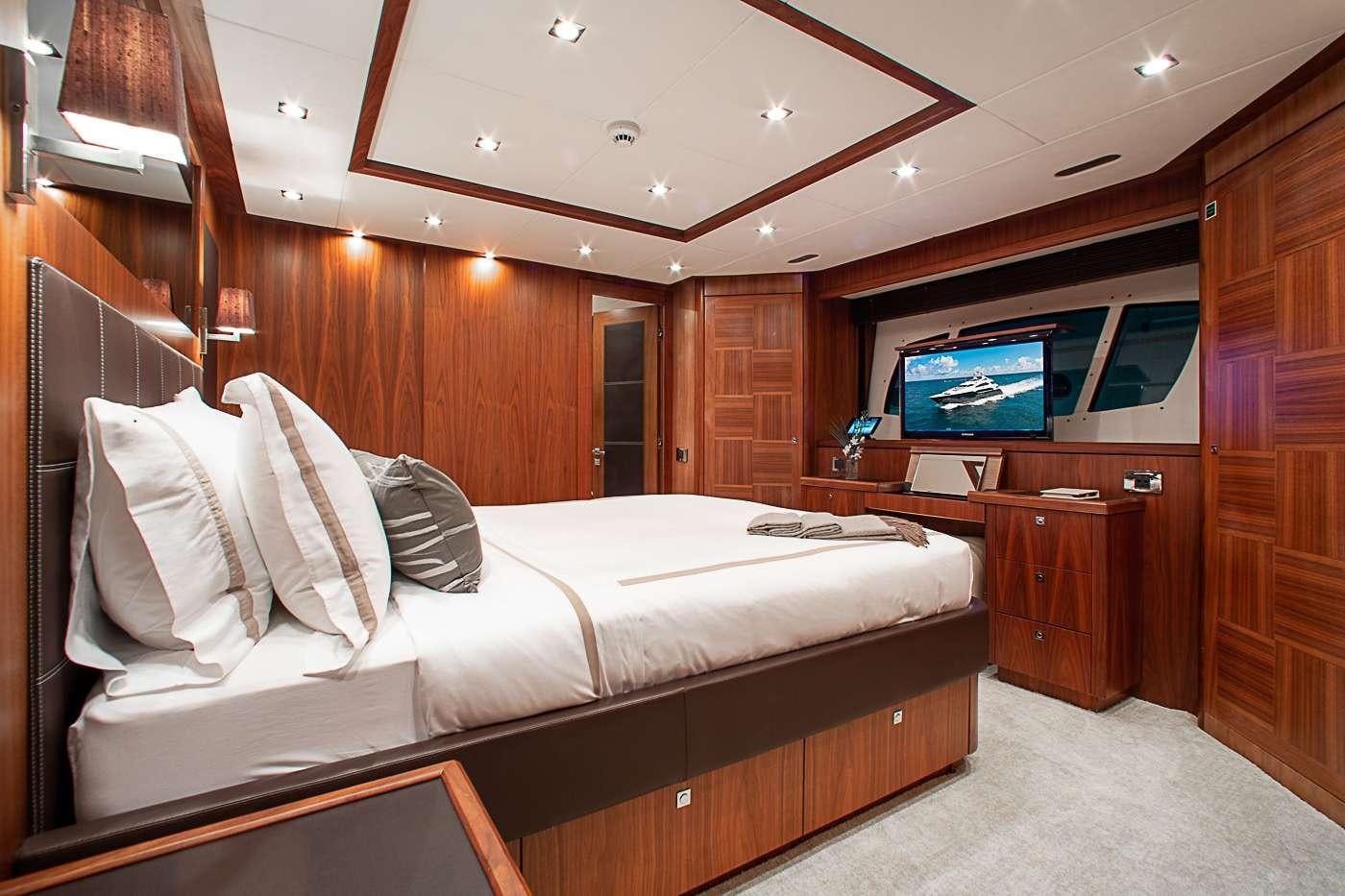 a room with a bed and a television aboard ACACIA Yacht for Charter