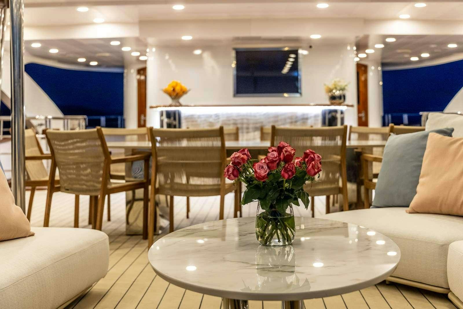 a vase of flowers on a table aboard OLIMP Yacht for Charter
