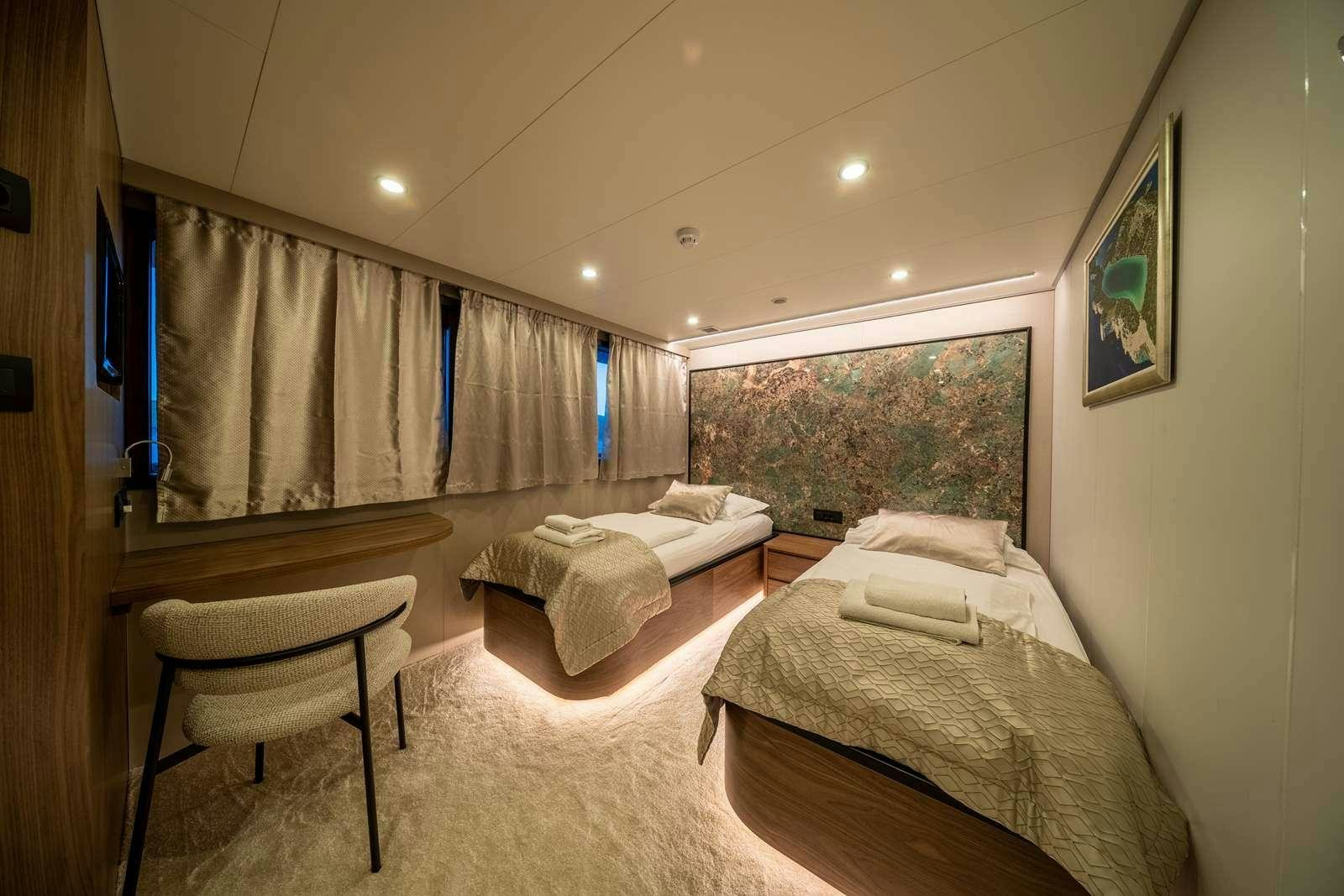 a room with two beds aboard OLIMP Yacht for Charter