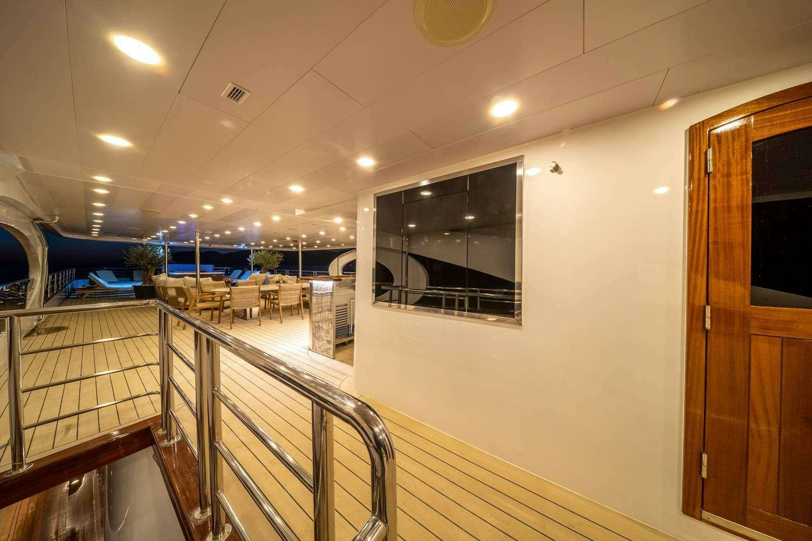 a room with tables and chairs aboard OLIMP Yacht for Charter