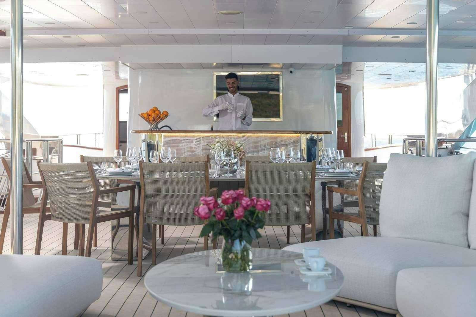 a person standing in a living room aboard OLIMP Yacht for Charter