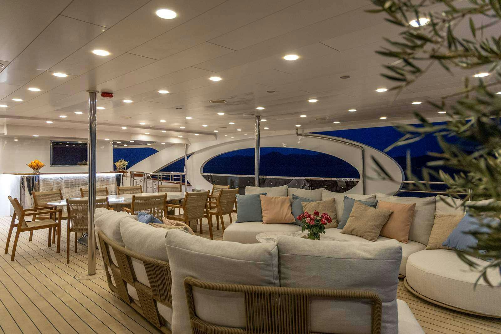 a large room with a large blue swimming pool and a large white couch aboard OLIMP Yacht for Charter
