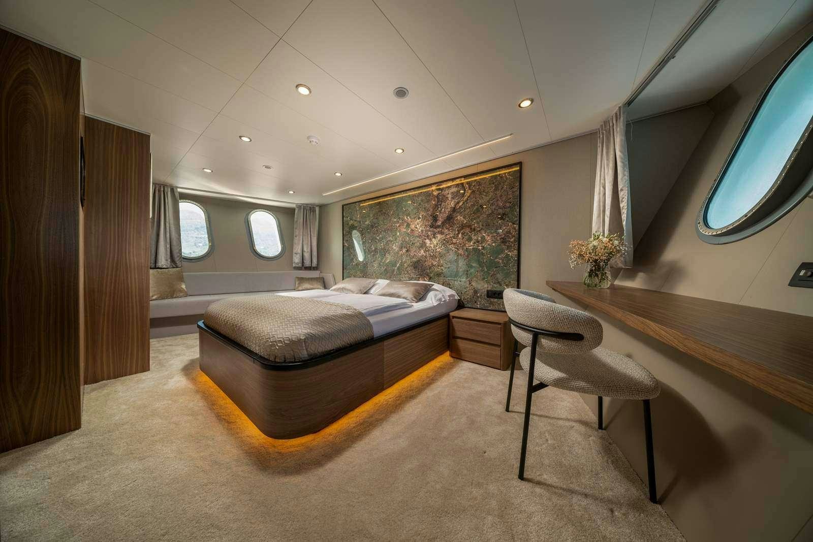 a bedroom with a bed and a desk aboard OLIMP Yacht for Charter