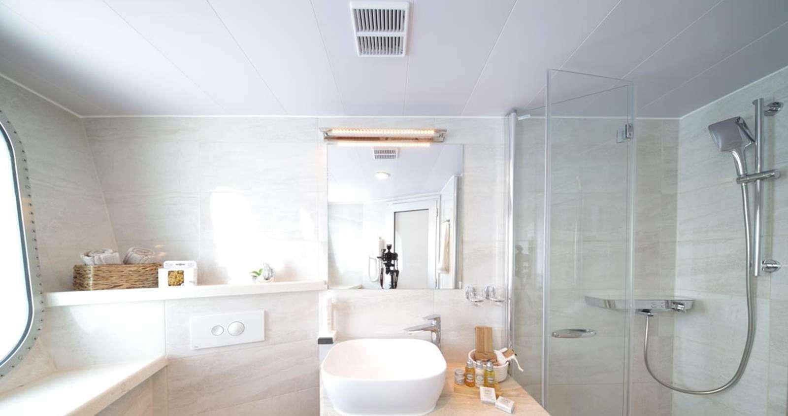 a bathroom with a glass shower aboard OLIMP Yacht for Charter