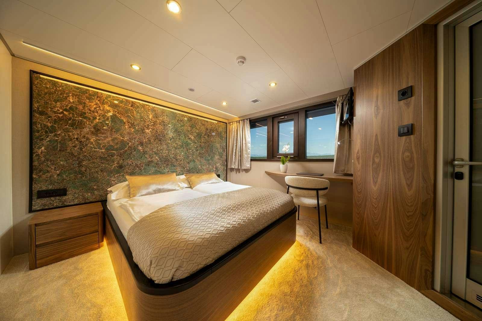 a bedroom with a bed and a table aboard OLIMP Yacht for Charter