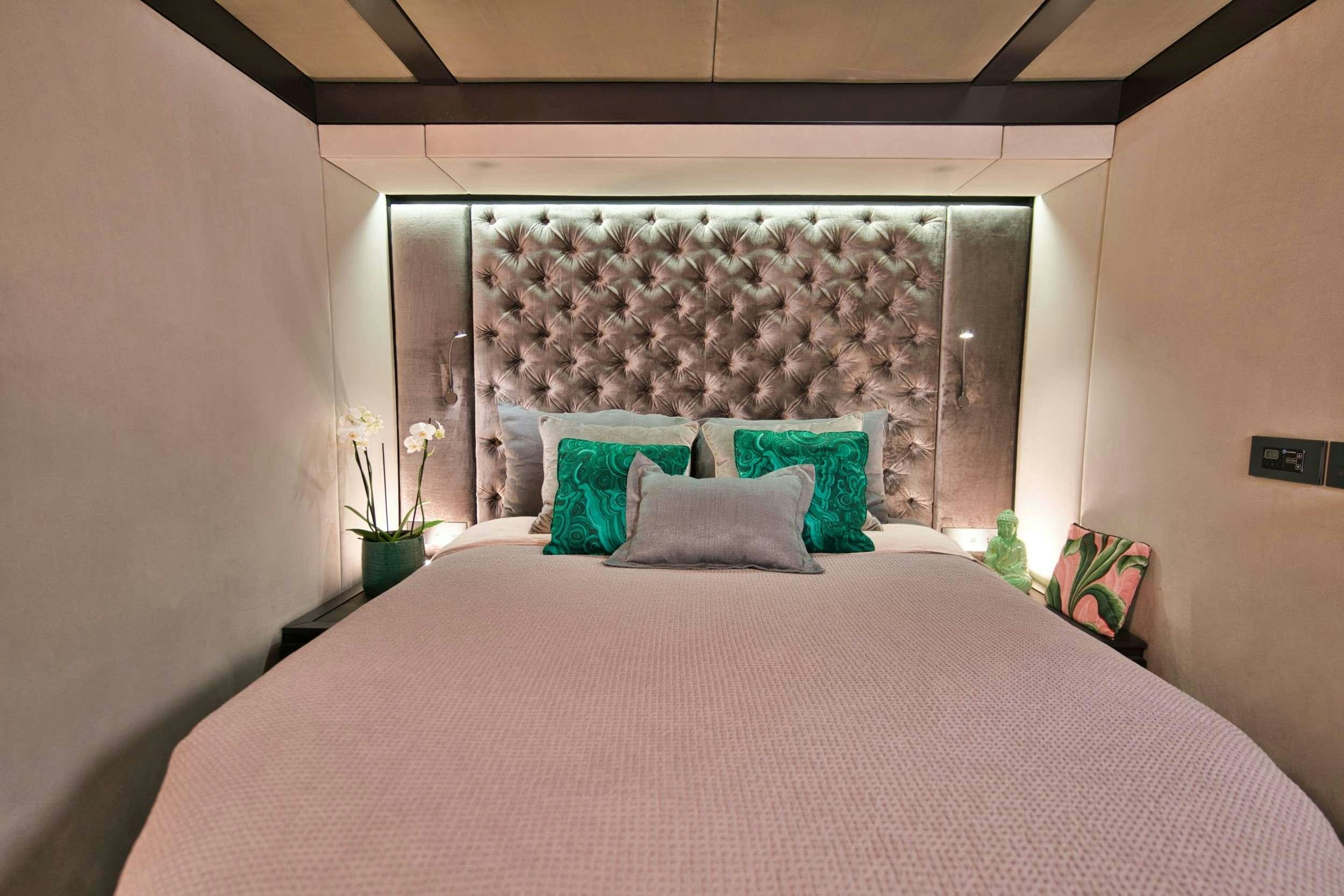 a bed with pillows and a window aboard GINETTE Yacht for Charter