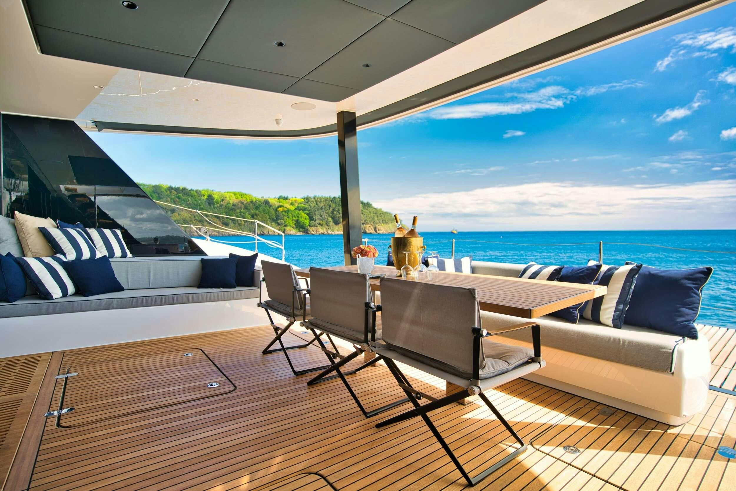 a room with a table chairs and a view of the ocean aboard GINETTE Yacht for Charter