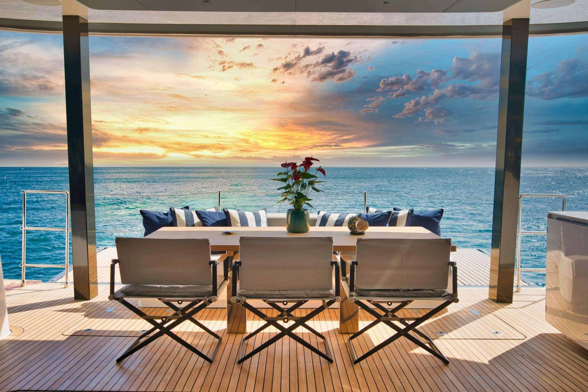 a table and chairs on a deck overlooking a body of water aboard GINETTE Yacht for Charter
