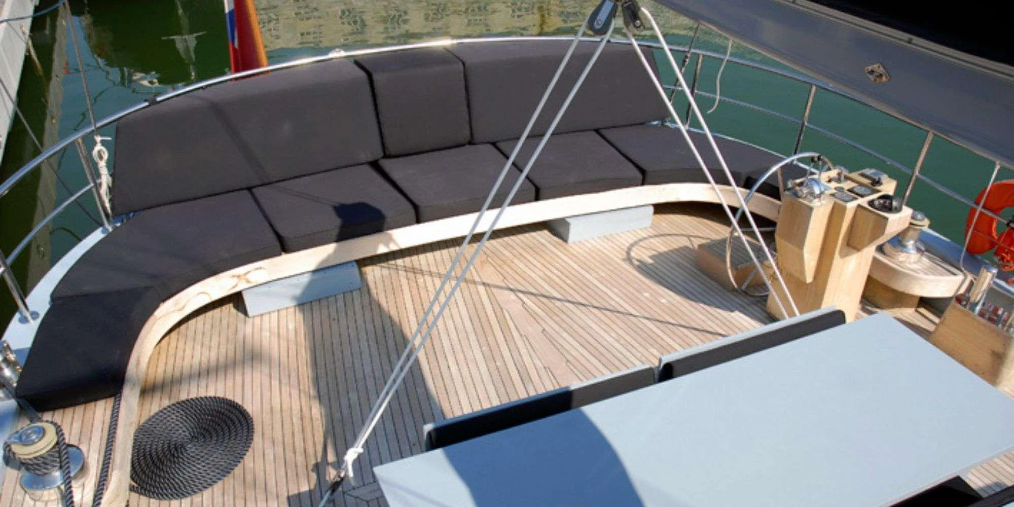 The aft deck features a spacious seating area with plush cushions and a well-appointed table, perfect for outdoor relaxation. aboard LA MER Yacht for Charter