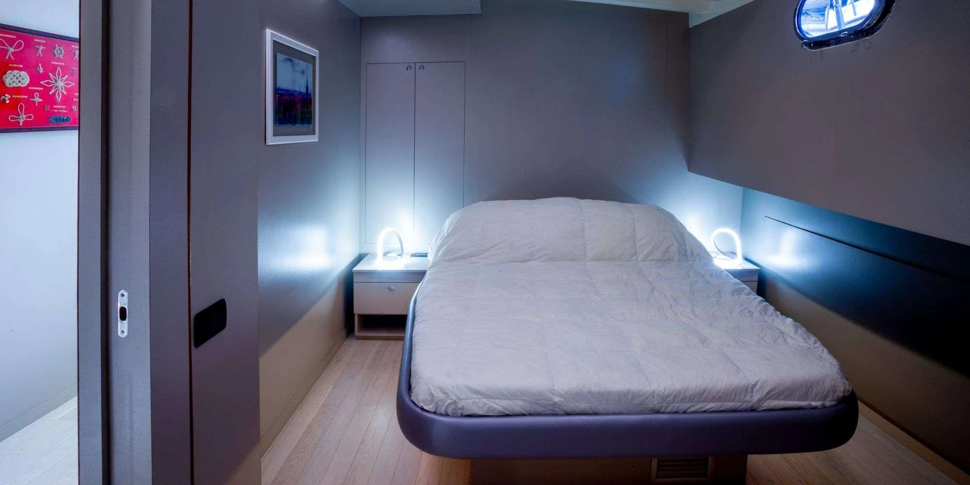 A cozy stateroom featuring a comfortable bed and modern lighting. aboard LA MER Yacht for Charter
