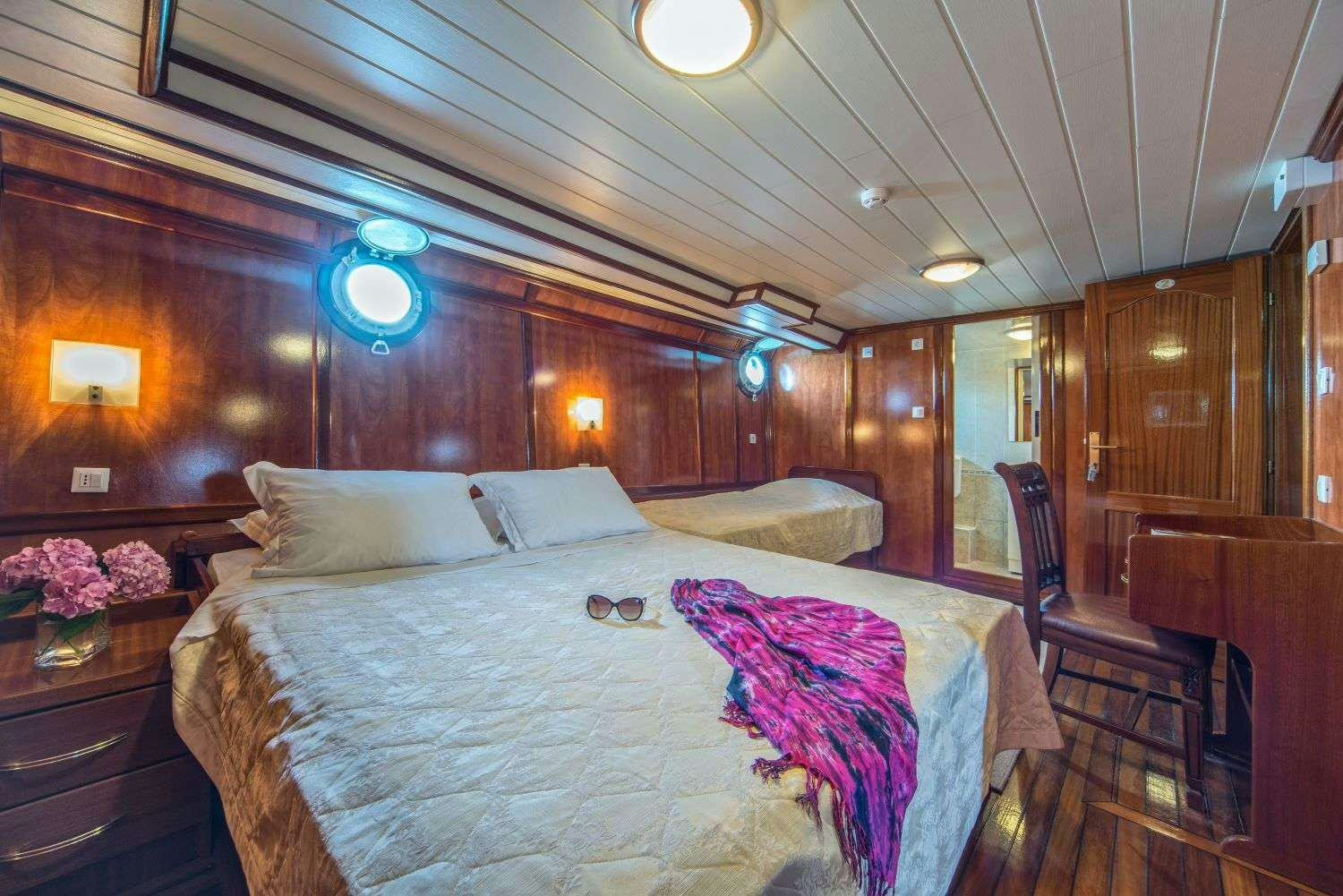 a bed with a purple blanket aboard LUNA Yacht for Charter
