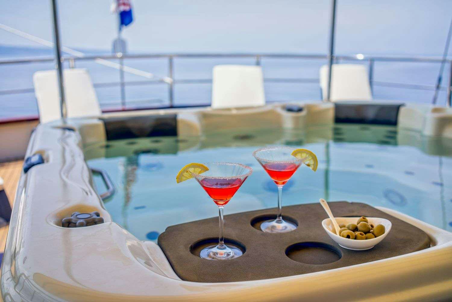 a glass of red wine on a table with a plate of food and a glass of red wine aboard LUNA Yacht for Charter