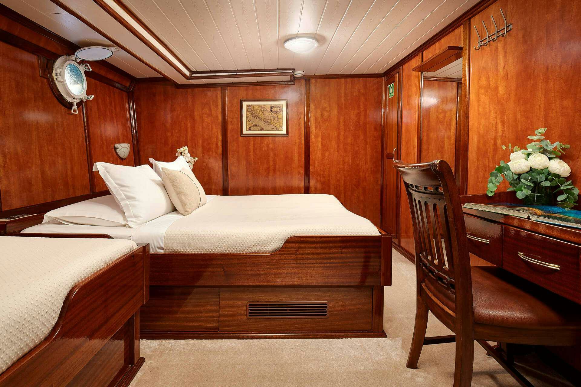 a room with a bed and a chair aboard LUNA Yacht for Charter