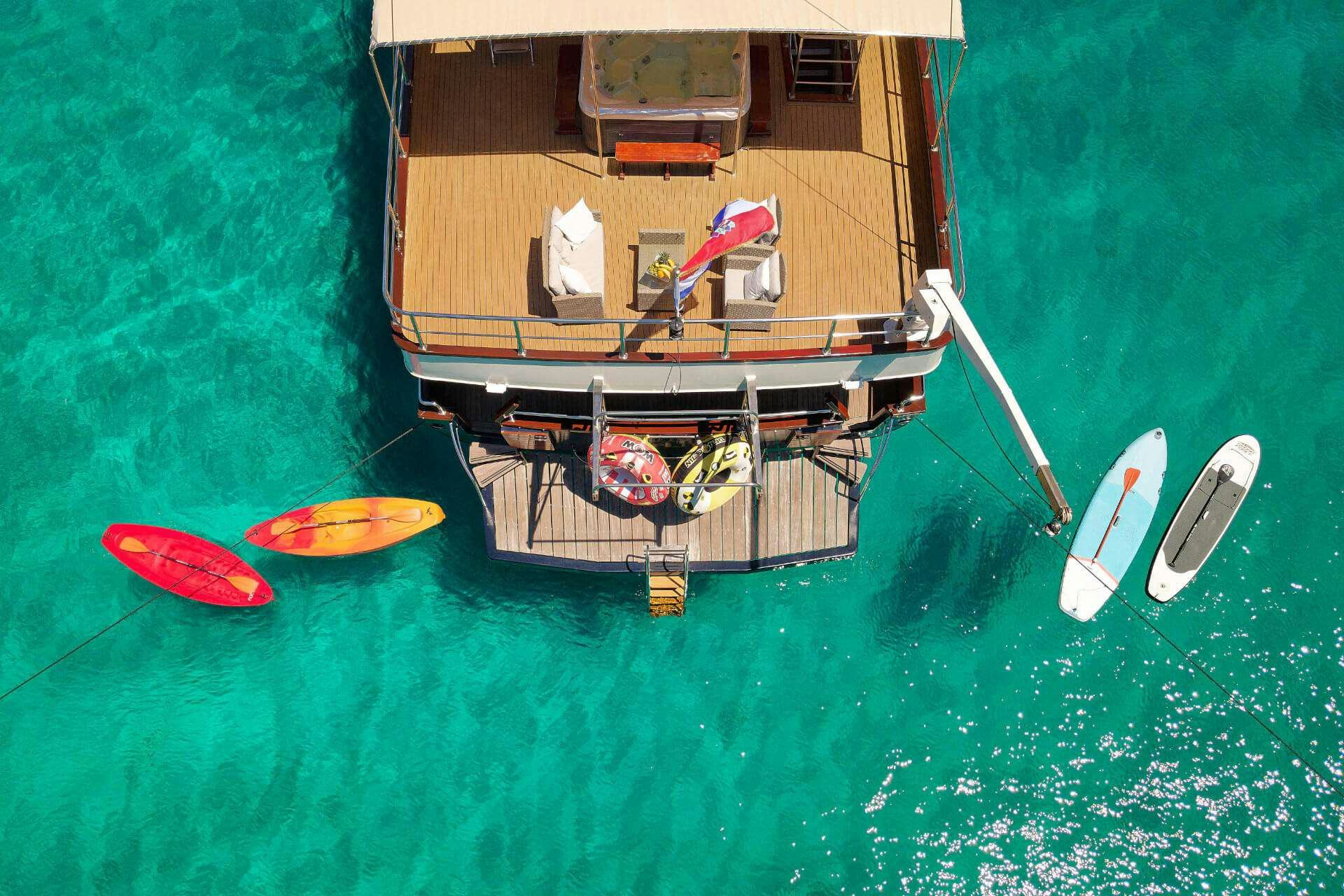 a boat with a paddle and surfboards on it aboard LUNA Yacht for Charter