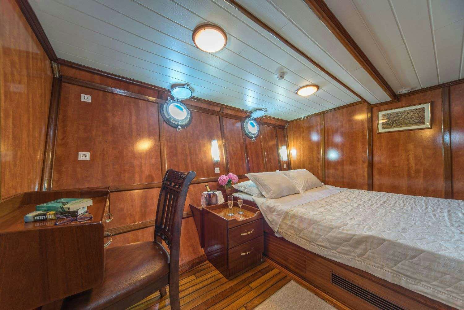 a bedroom with a bed and a desk aboard LUNA Yacht for Charter