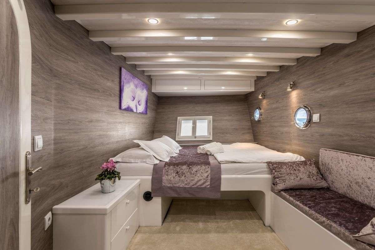 a room with a couple of beds aboard ANDEO Yacht for Charter