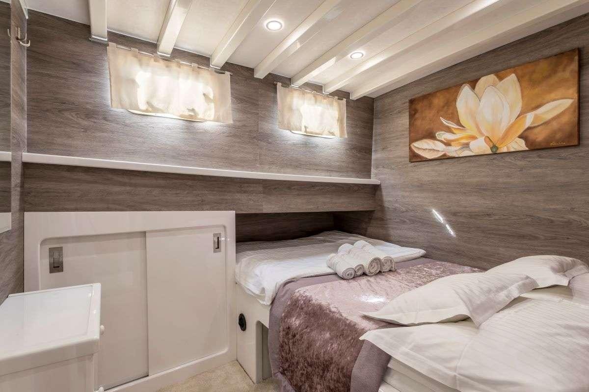 a room with a bed and a fireplace aboard ANDEO Yacht for Charter