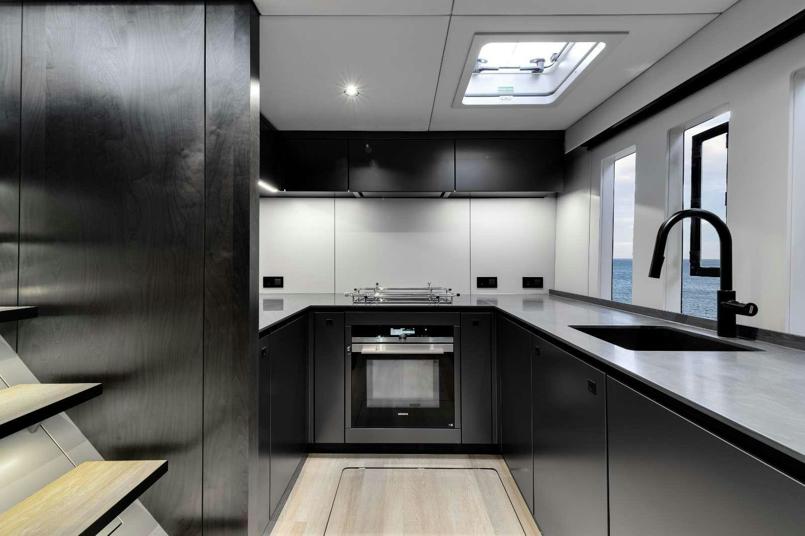 a kitchen with black cabinets aboard AGATA BLU Yacht for Charter