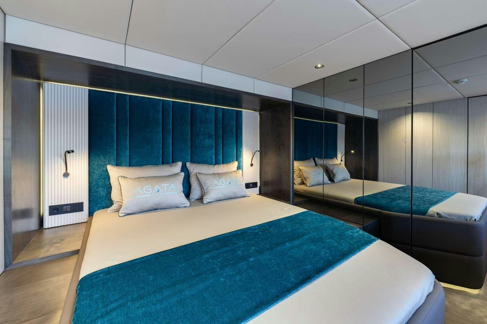 a room with a bed and a blue curtain aboard AGATA BLU Yacht for Charter