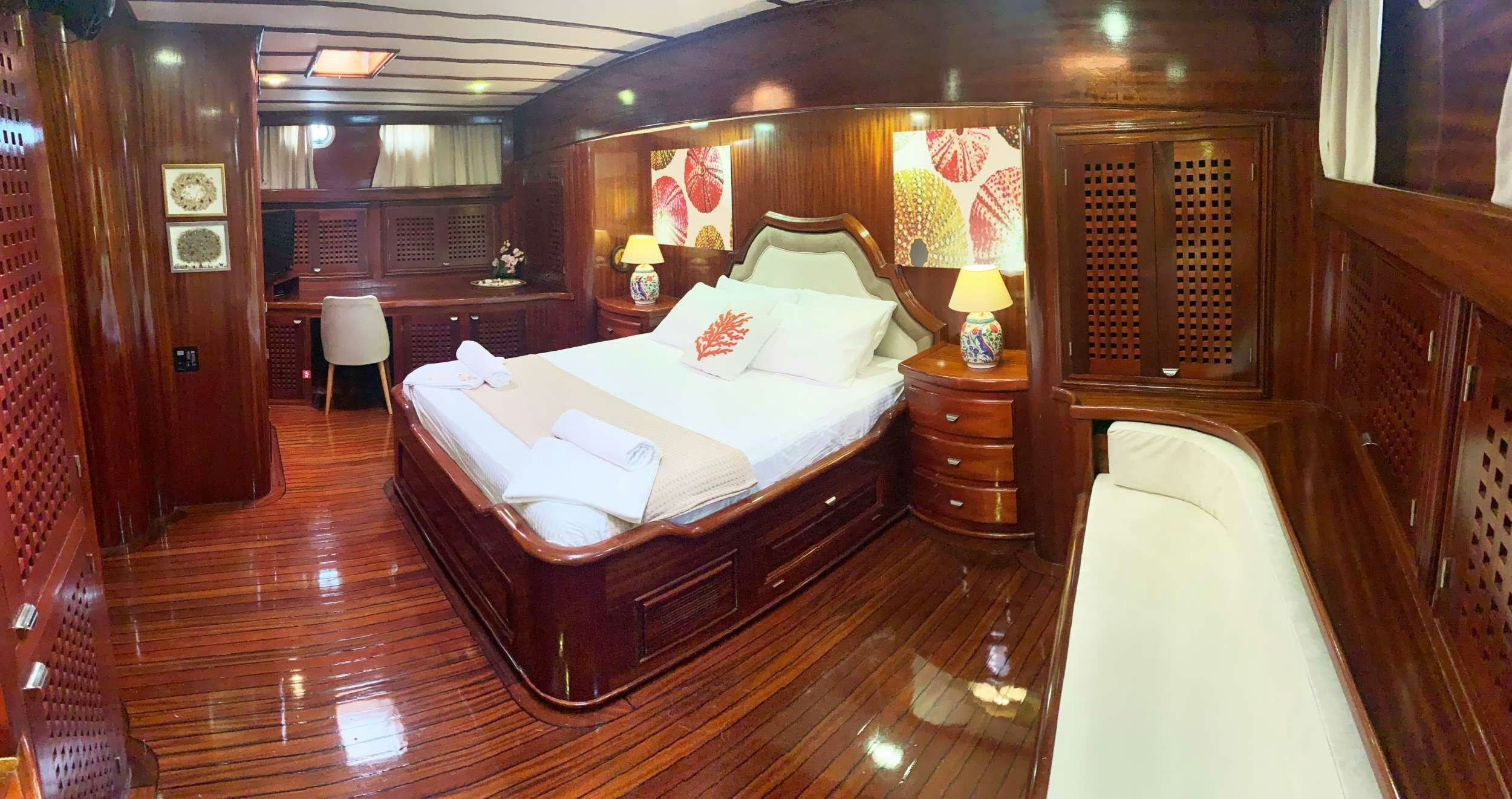 a room with a bed and a desk aboard ELIANORA Yacht for Charter
