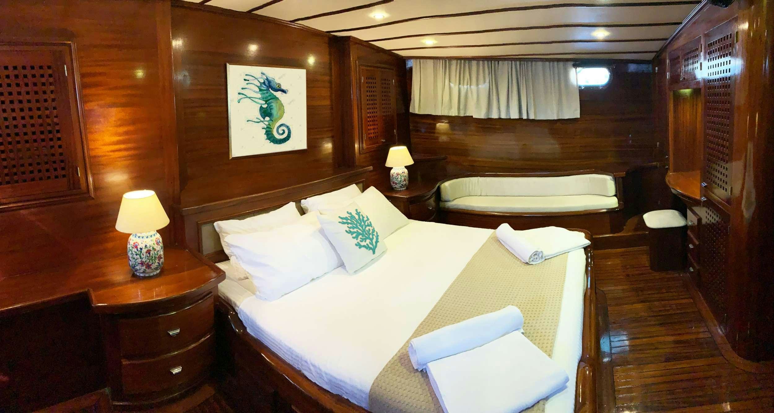 a room with a bed and a chair aboard ELIANORA Yacht for Charter